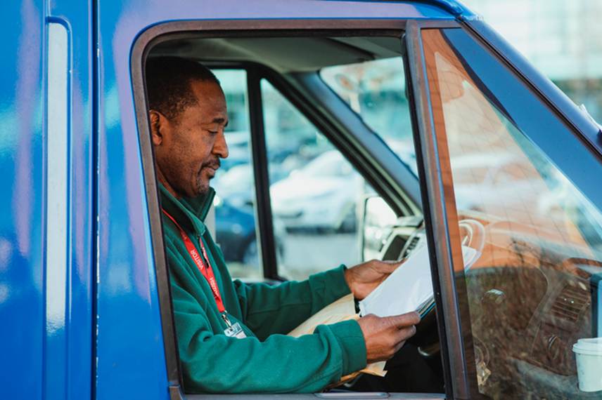 Man looking over paperwork in car - Unpaid Wages